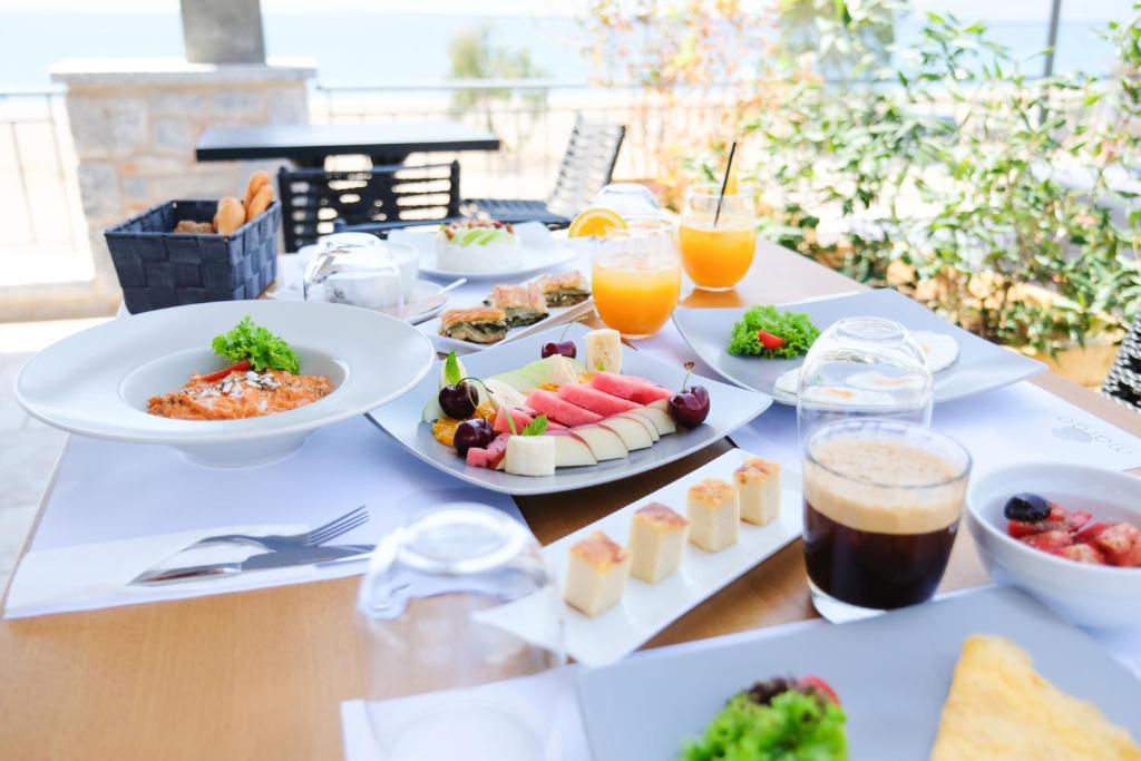 a table topped with plates of food and drinks at Margo Beach Hotel in Gythio