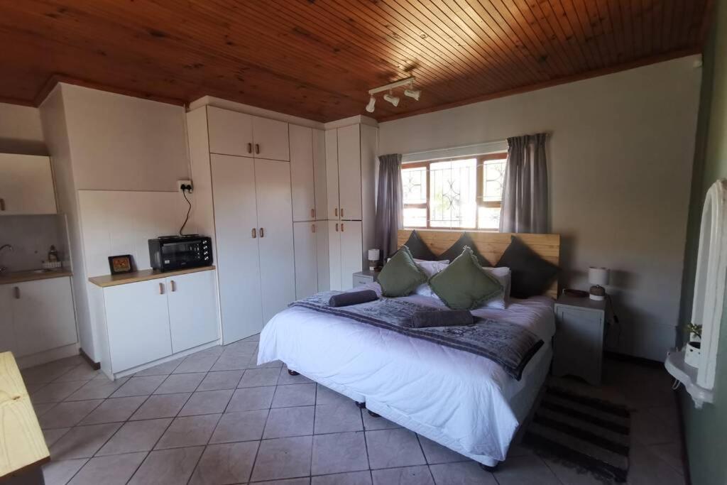 a bedroom with a large bed in a room at Cozy, peaceful garden cottage in Cape Town