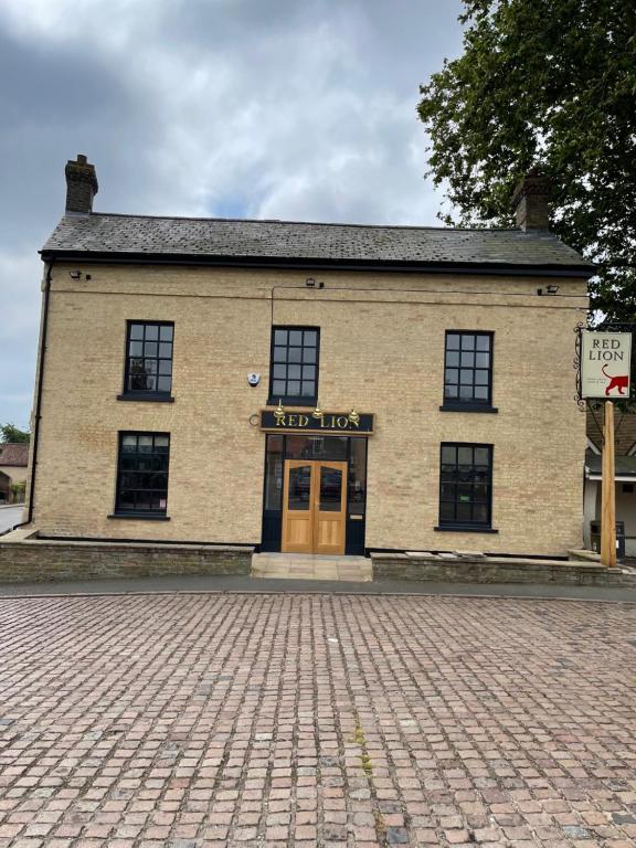 a brick building with a door on a street at The Red Lion, Stretham in Ely