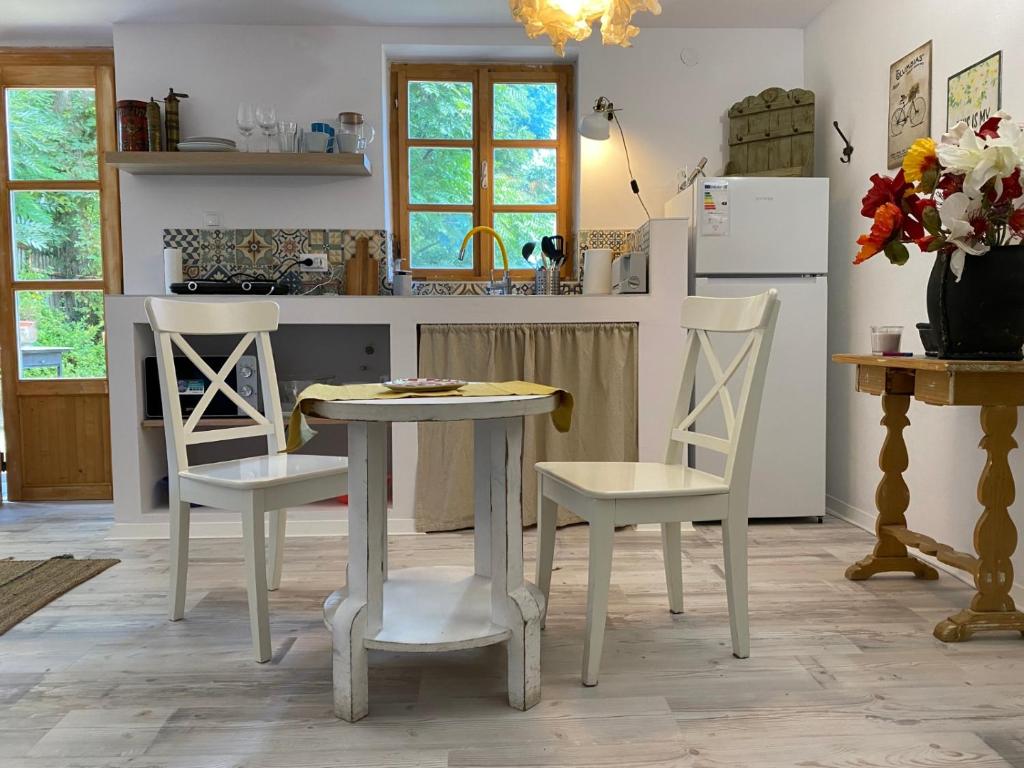 kuchnia ze stołem, 2 krzesłami i lodówką w obiekcie Countryside w mieście Füle