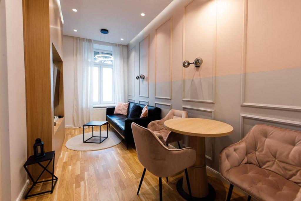 salon ze stołem, krzesłami i kanapą w obiekcie ZEUS Design Apartments Wasserwelt w Wiedniu