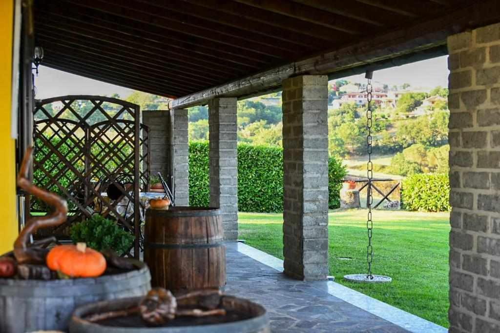 een veranda met uitzicht op een groene tuin bij Agriturismo Bella Cima in Montefiascone