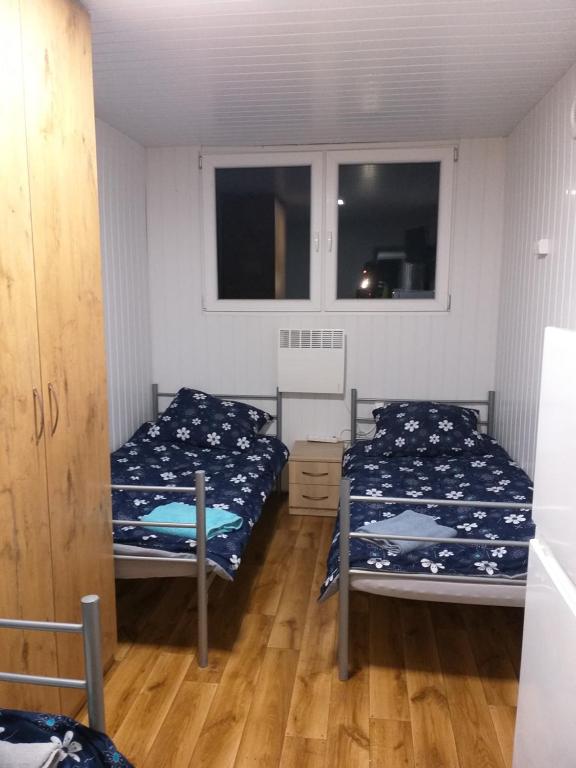 1 dormitorio con 2 camas y 2 ventanas en Domek N5 - 2 Pokoje , Kuchnia , Łazienka 5 osobowy - FreezerHause Izdebno- NoclegiGrodziskPL en Grodzisk Mazowiecki