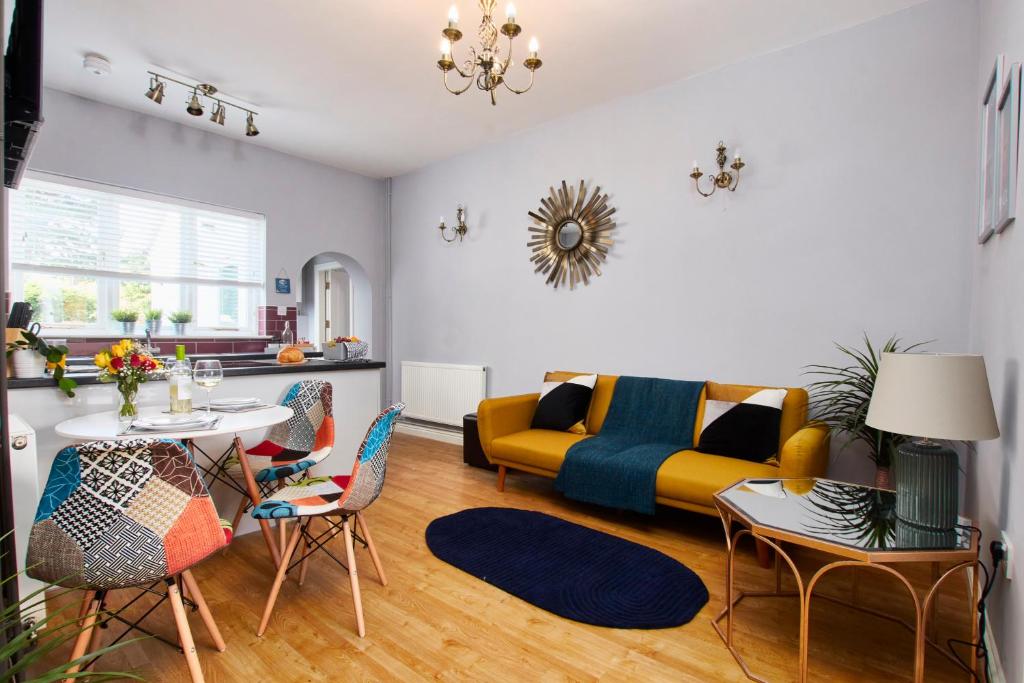 a living room with a couch and a table and chairs at Delven House, Apartment 1 in Castle Donington