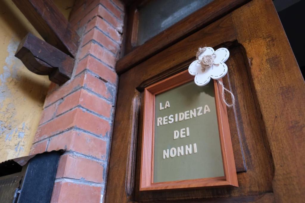 una señal en el lado de un edificio con una flor en él en La Residenza dei Nonni, en Montefranco