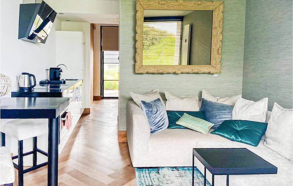 salon z białą kanapą i lustrem w obiekcie De Duinparel w mieście Bergen aan Zee