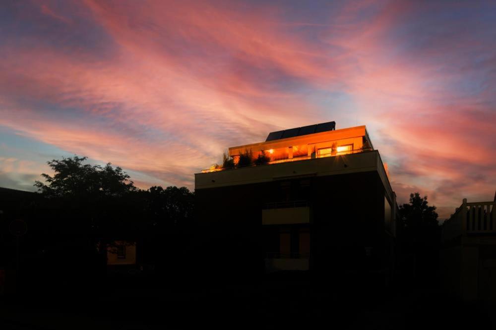 ein Gebäude mit Lichtern bei Sonnenuntergang in der Unterkunft Penthouse@the sea in Scharbeutz
