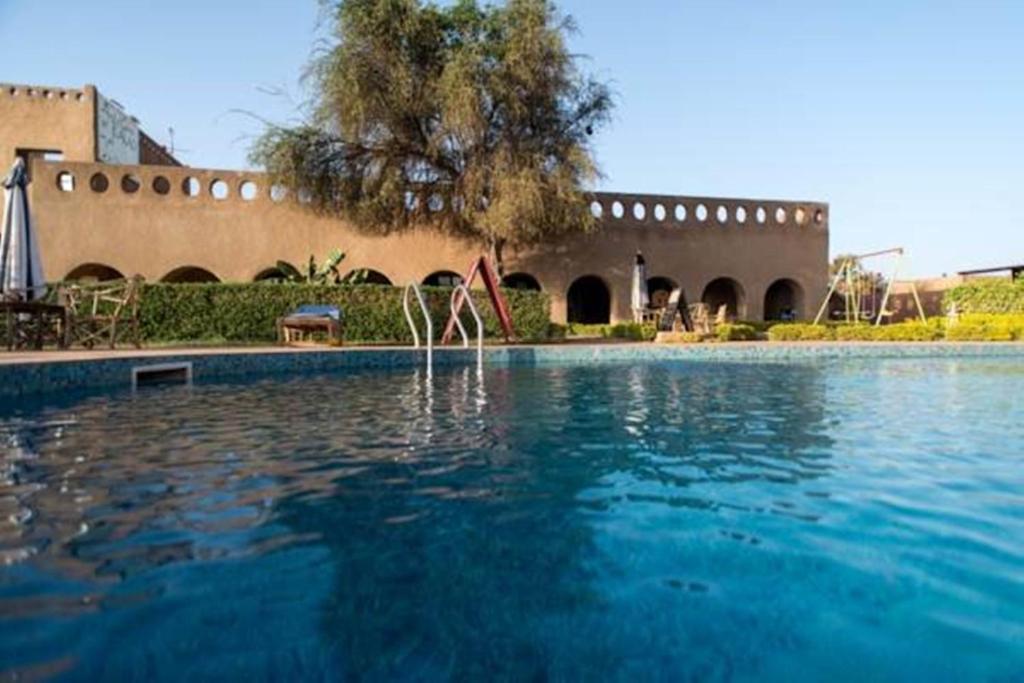 a swimming pool in front of a building at Le Grand Calao in Ouagadougou