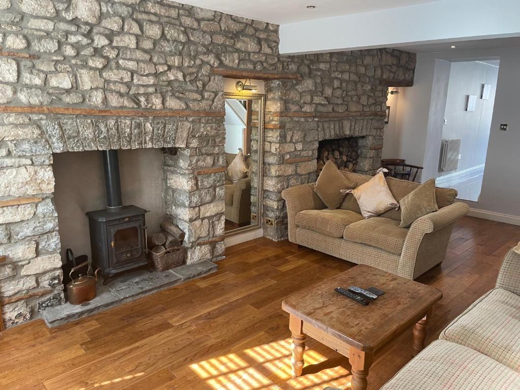 a living room with a stone fireplace and a couch at 17 Eastgate in Cowbridge