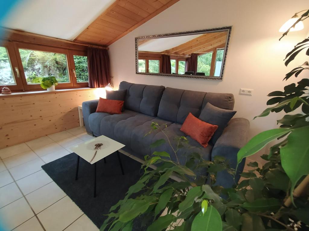 a living room with a blue couch and a mirror at HAPPY PLACE Pusteblume in Halblech