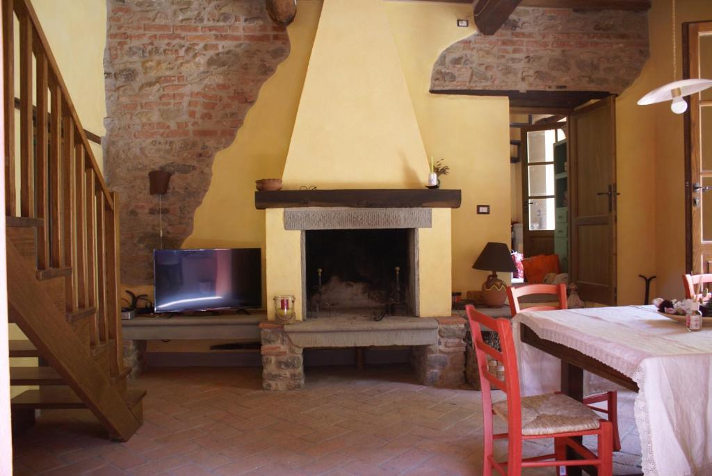 a living room with a fireplace and a tv at Tradizione Toscana ristrutturata nel 2021 in Barga