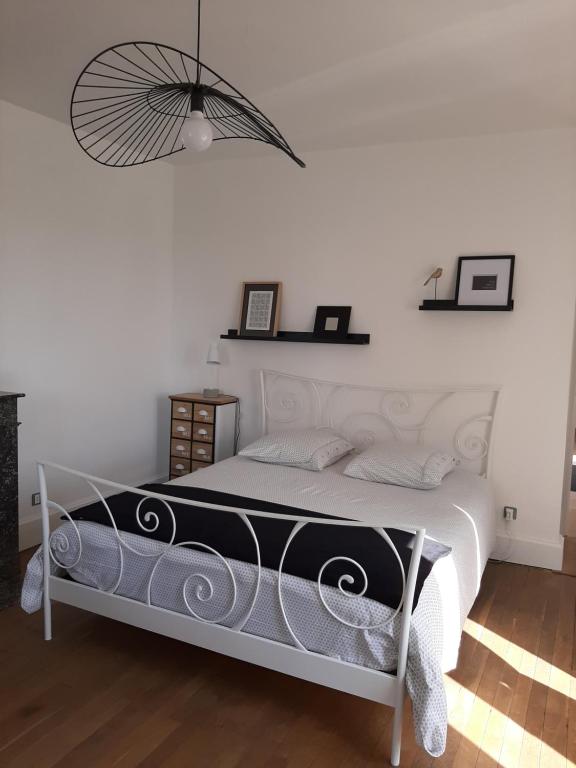 a bedroom with a bed with a black and white comforter at Gîte des Agapanthes in Lacroix-sur-Meuse