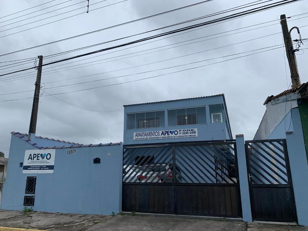 a building with a gate with a sign on it at APEVO ILHA in Ilha Comprida