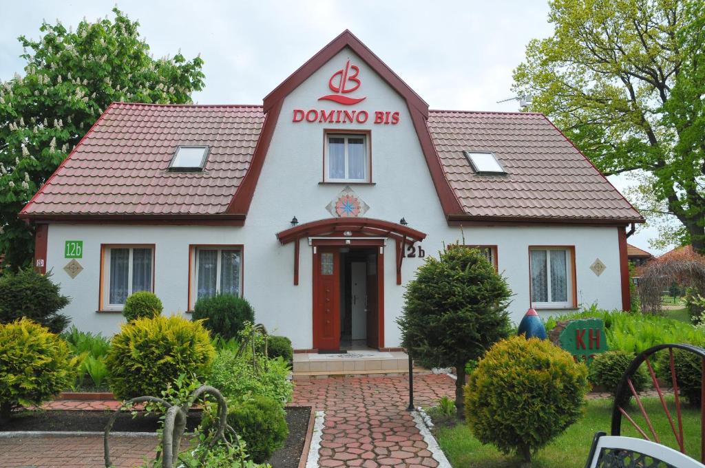 a house with a dominoes sign on it at Ośrodek Wczasowy Domino Bis in Dźwirzyno