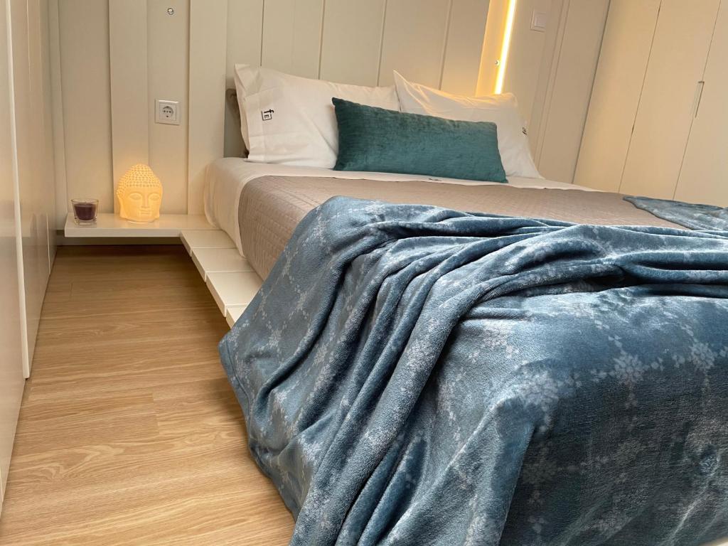 ein Schlafzimmer mit einem Bett mit einer blauen Decke darauf in der Unterkunft Vila do Conde - Os Maias in Vila do Conde