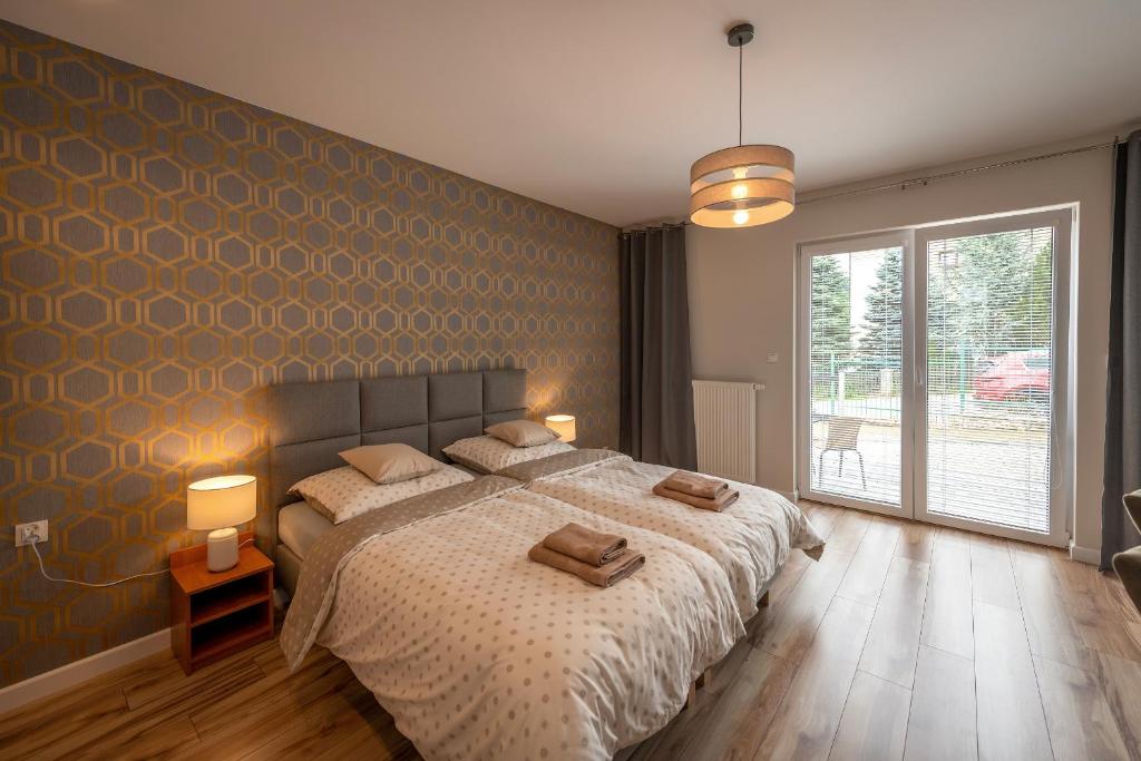 ein Schlafzimmer mit einem großen Bett mit zwei Kissen darauf in der Unterkunft Apartamenty Mozaika - centrum Zdroju in Lądek-Zdrój