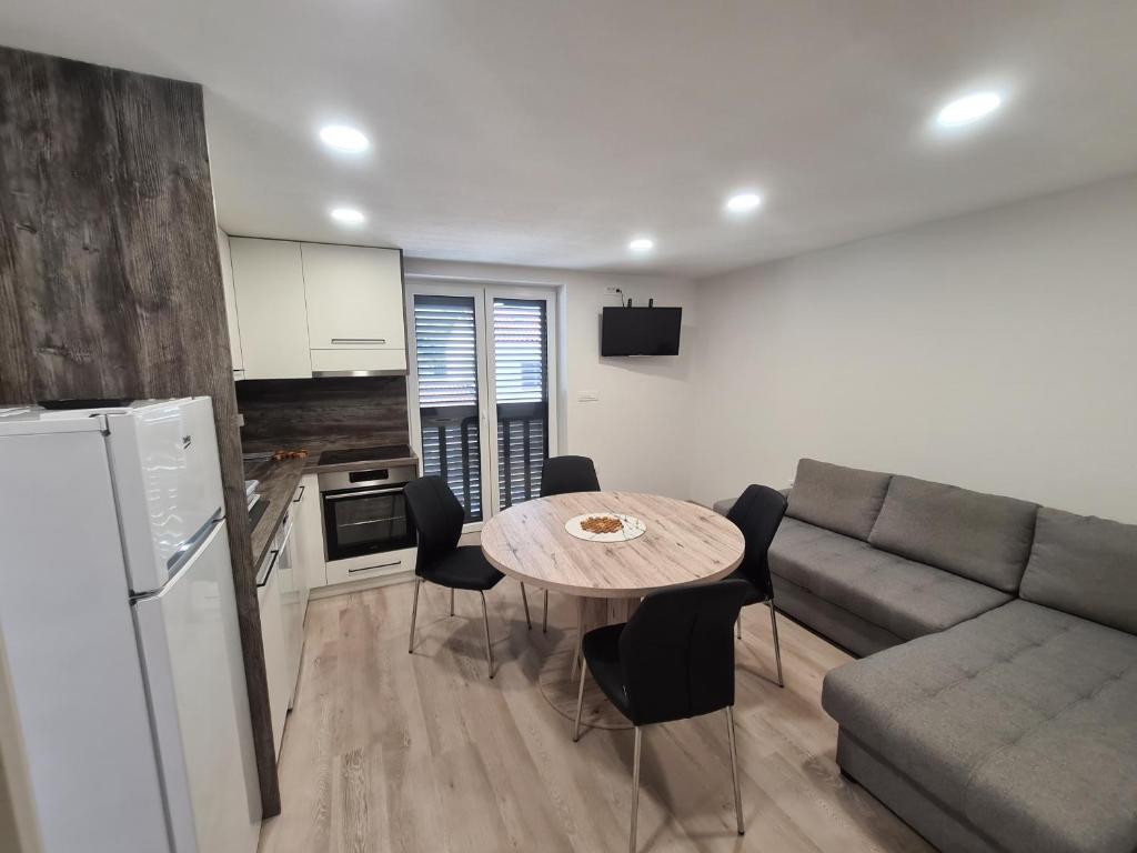 a kitchen and a living room with a table and a couch at Portorož Apartments in Portorož