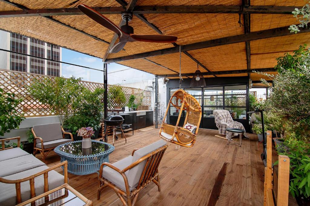 an outdoor patio with chairs and a mirror at Unique solar penthouse with jacuzzi and sauna in central Athens in Athens