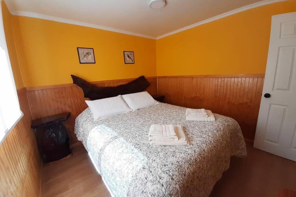 een slaapkamer met een bed met twee handdoeken erop bij Pillang Likan tinas calientes, el poder del Volcan in Puerto Varas