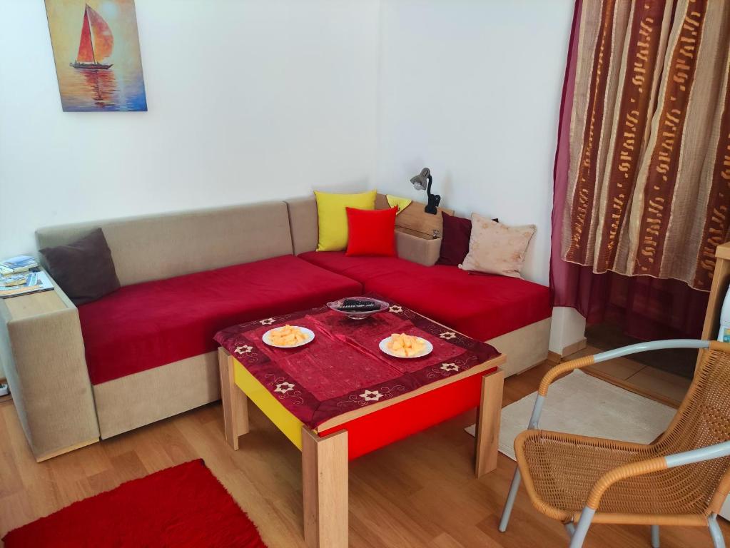 a living room with a red couch and a table at Studio Yana *Top location*Sea Garden* in Varna City