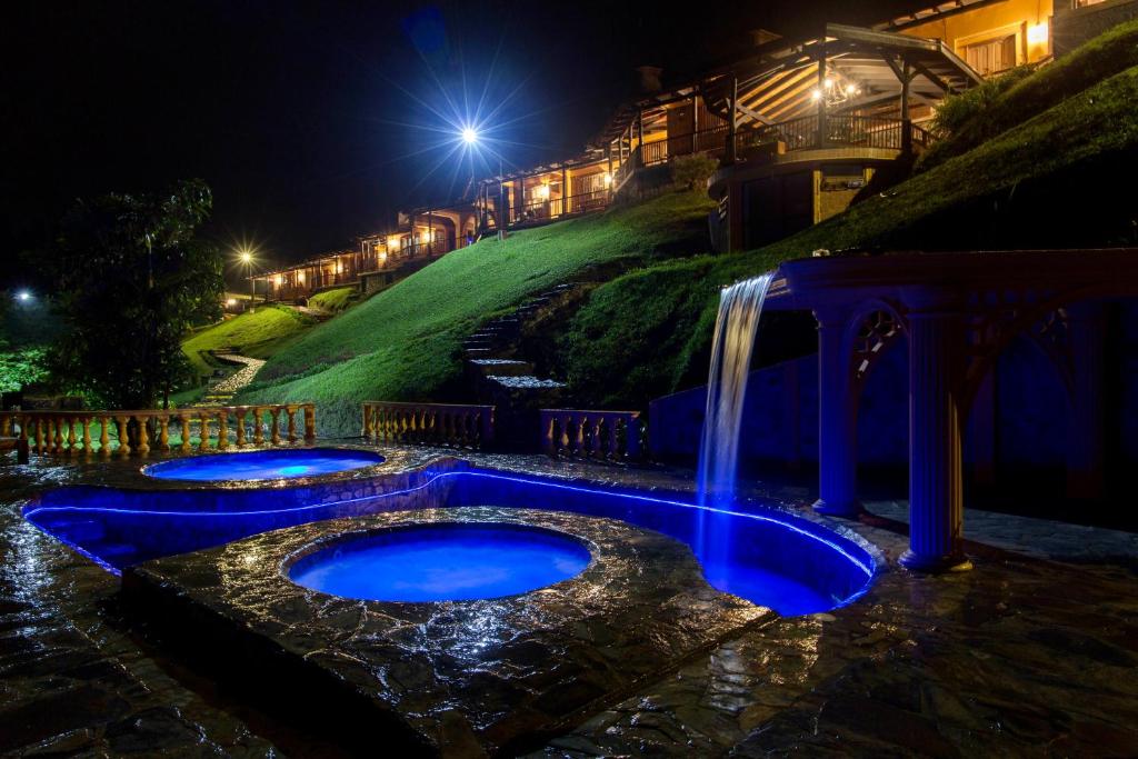a pool with a waterfall in the middle of a yard at night at Rancho San Antonio in Salento