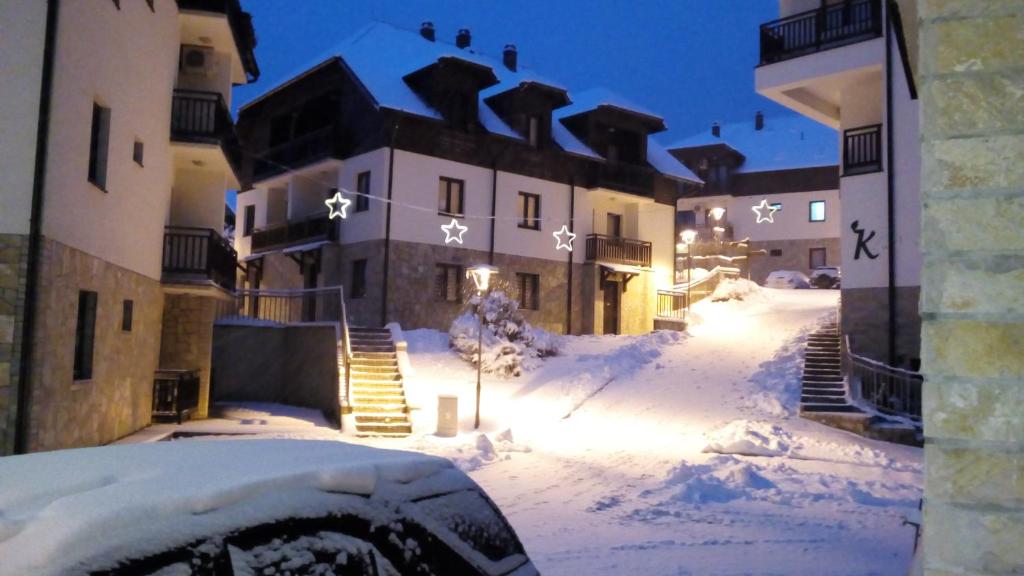 uma rua coberta de neve em frente a um edifício em Zlatibor Katarina apartman em Zlatibor