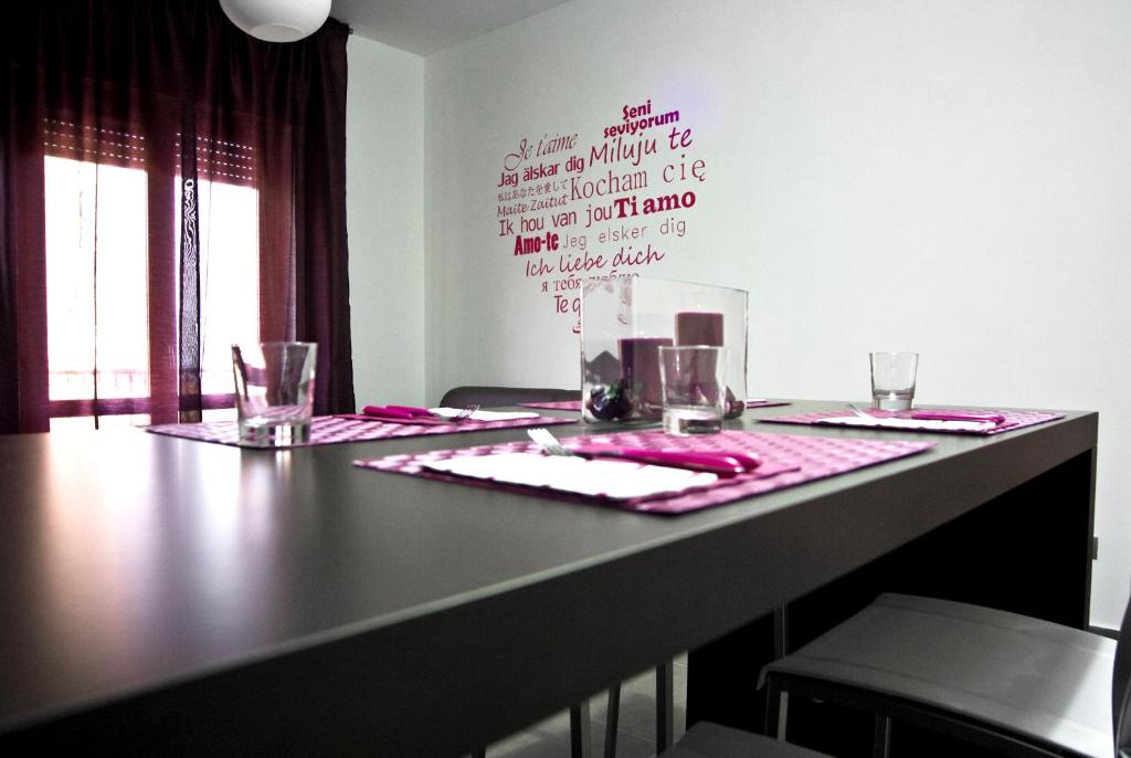 a table with a pink table cloth and glasses on it at inStile aparthotel in Ascea