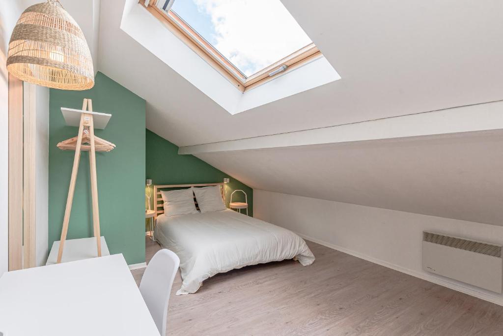 a attic bedroom with a bed and a skylight at matcha wood - matcha home Koenigsmacker in Koenigsmacker
