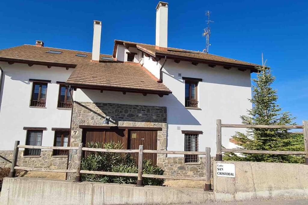 una gran casa blanca con una valla de madera delante de ella en Badaguás (Jaca) - Duplex en el Pirineo, en Jaca