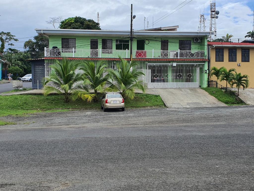 un coche aparcado frente a una casa verde en Limon Condos near LIO Intl Airport - 777L , Self Check-in, en Puerto Limón
