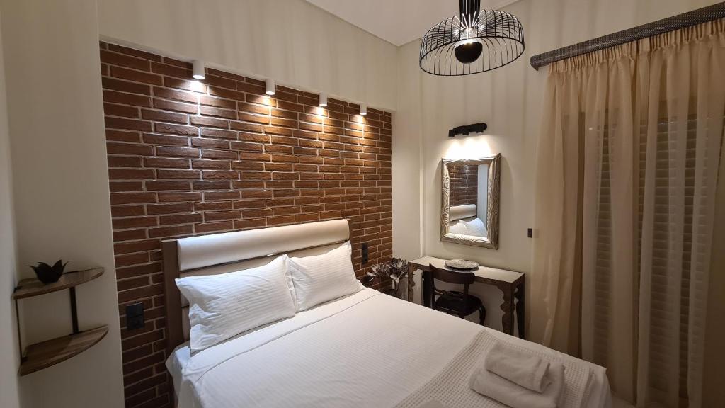 Un dormitorio con una cama con una pared de ladrillos. en Oikion Meteora Home 2, en Kalambaka