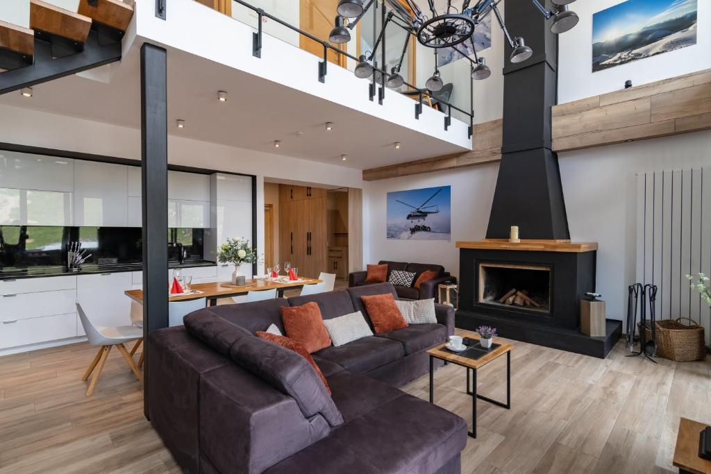 sala de estar con sofá y chimenea en 7 Senses Luxury Apartment, en Gudauri