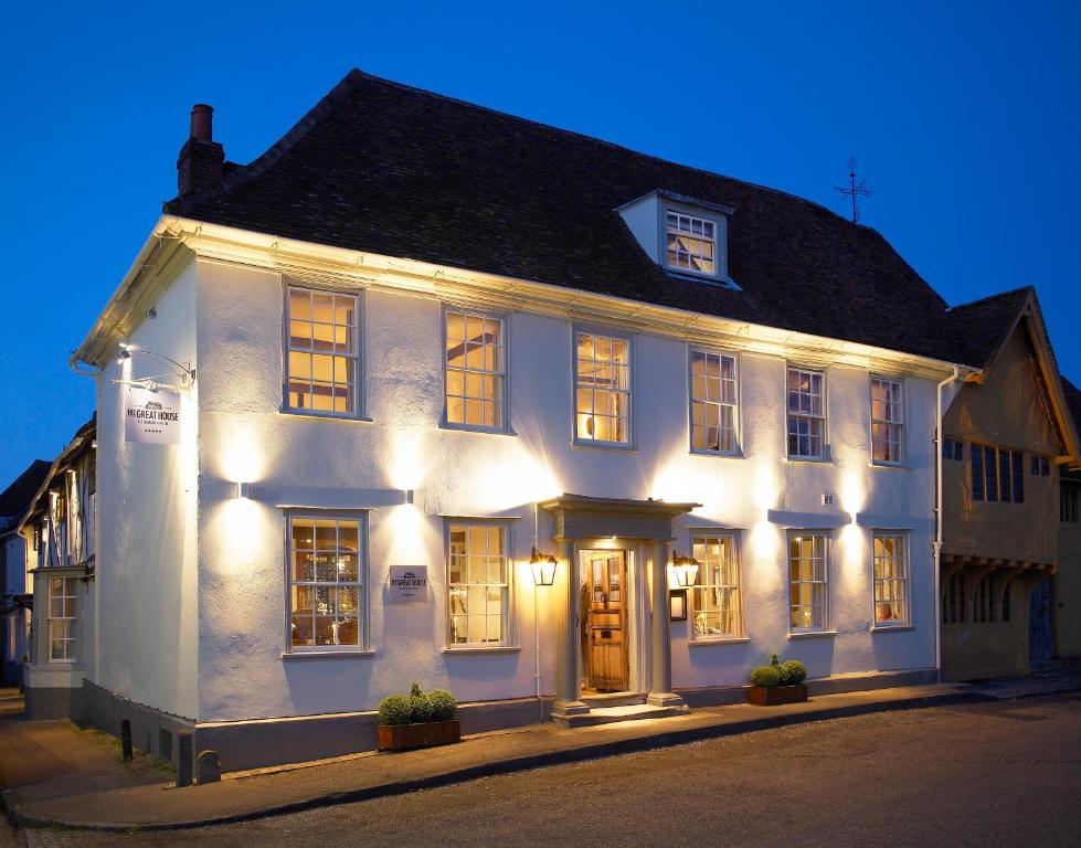 a white building with lights on a street at The Great House Lavenham Hotel & Restaurant in Lavenham