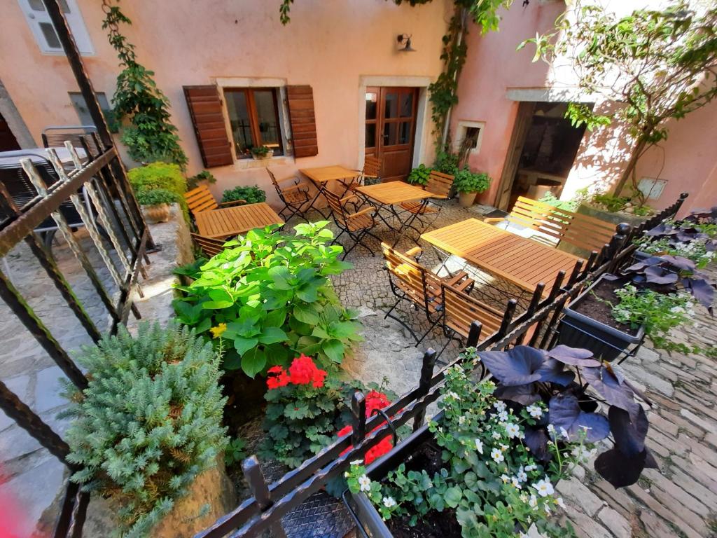 een patio met tafels, stoelen en planten bij Bed & Breakfast Antico in Motovun