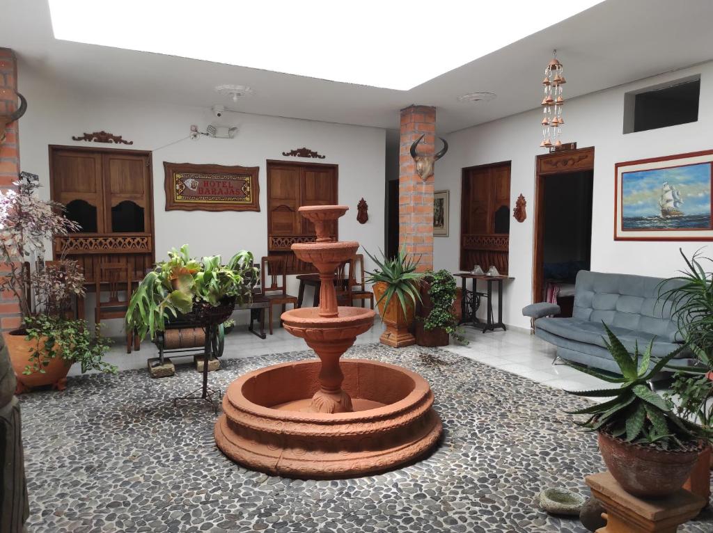- un salon avec une fontaine au milieu de la pièce dans l'établissement Hotel Barajas, à Jardín