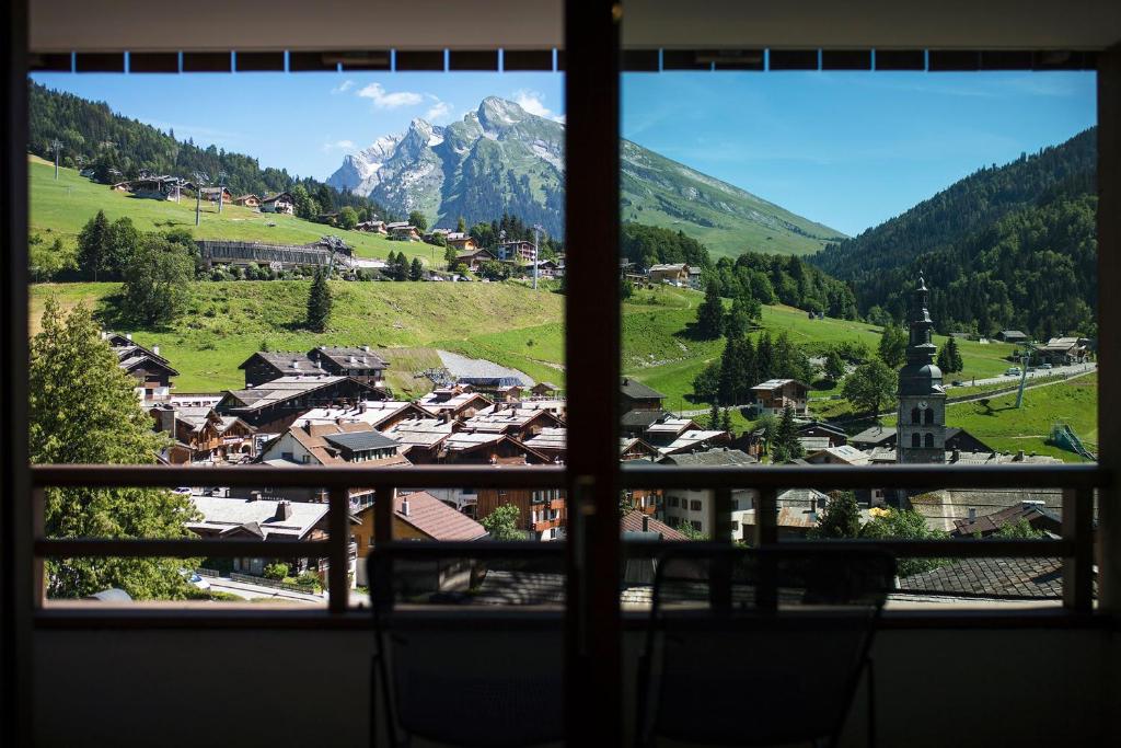 a view from a window of a village with a mountain at Résidence - Les Grandes Alpes in La Clusaz