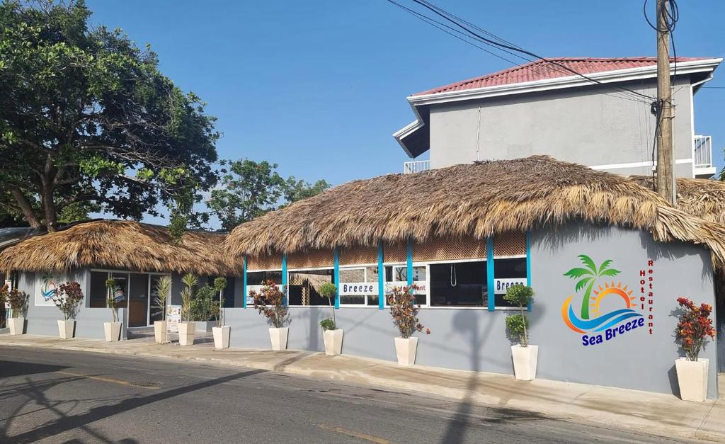 ein weißes Gebäude mit Strohdach in der Unterkunft Hotel Sea Breeze Sosua in Sosúa