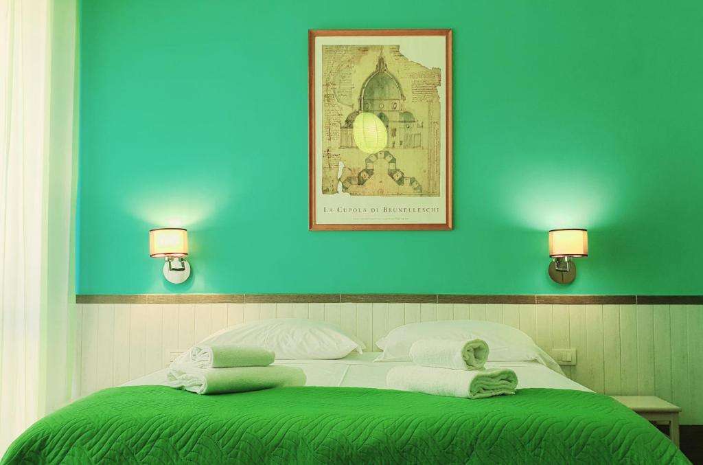 una camera con un letto verde e bianco con due luci di Il Giglio Guest House a Firenze
