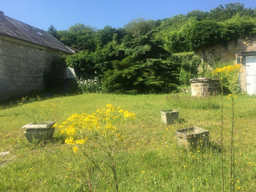 a yard with a field of grass and flowers at Le Refuge private entrance 2/4 pers dans maison 17eme siècle.Parking. calme in Autrêches