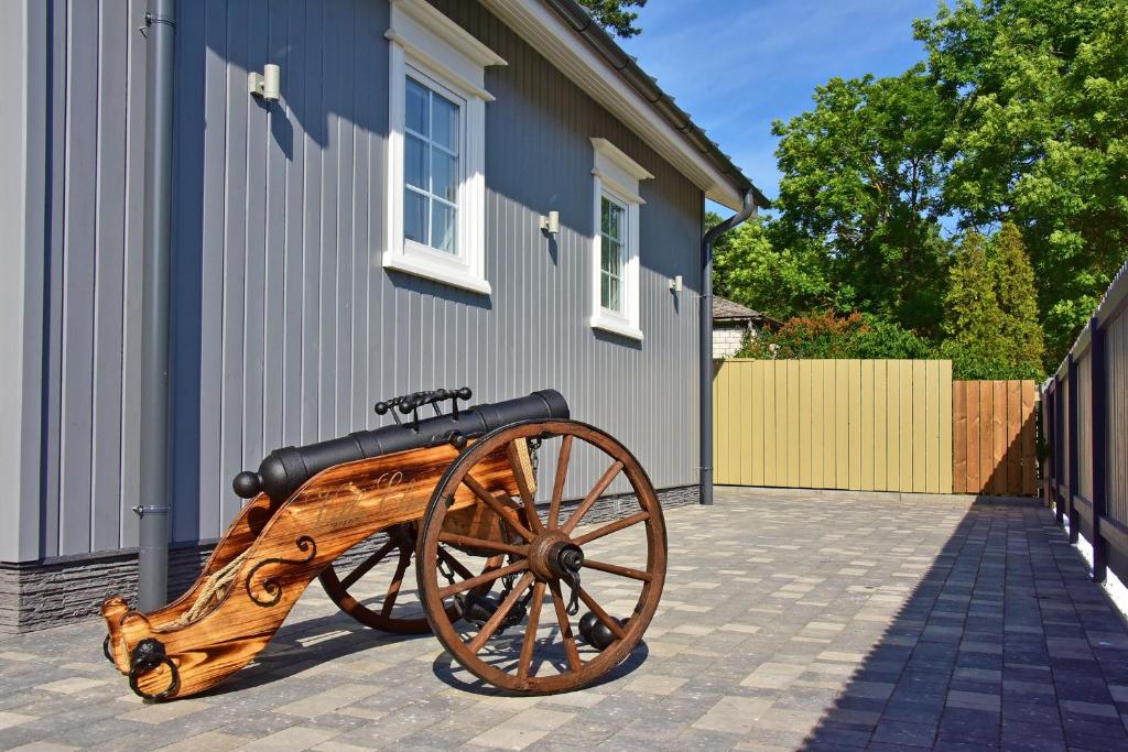 a wooden cart sitting outside of a building at Villa Elena in Ventspils