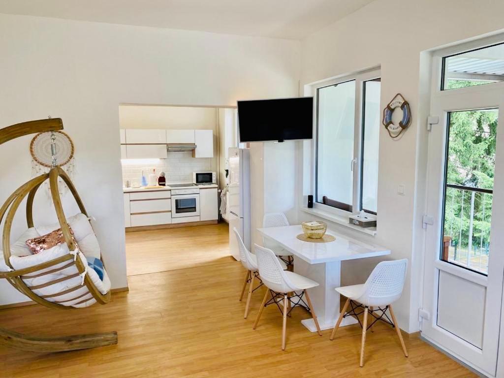 a living room with a table and chairs and a kitchen at Apartmán Linda Slapy- Ždáň in Slapy