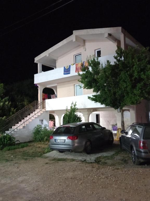 un'auto parcheggiata di fronte a una casa di notte di MD Apartmani Canj a Čanj