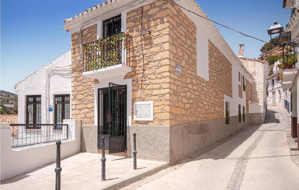 ein Backsteingebäude mit einer Tür auf einer Straße in der Unterkunft Lovely Apartment In Montefrio With Kitchen in Montefrío