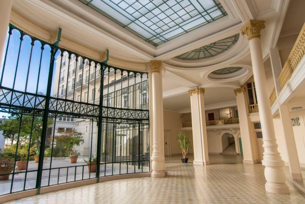 a large lobby with a glass ceiling and columns at Аpartements in the historical center df Vichy,hotel Imperial. in Vichy