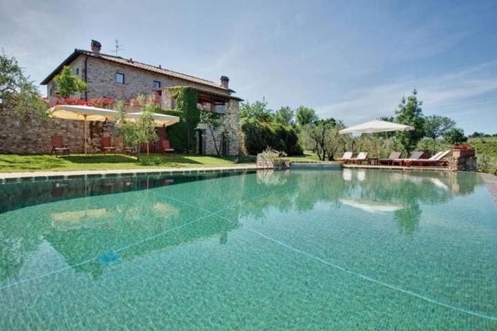 une grande piscine en face d'une maison dans l'établissement Villa Il Conventino, à Mercatale Val Di Pesa