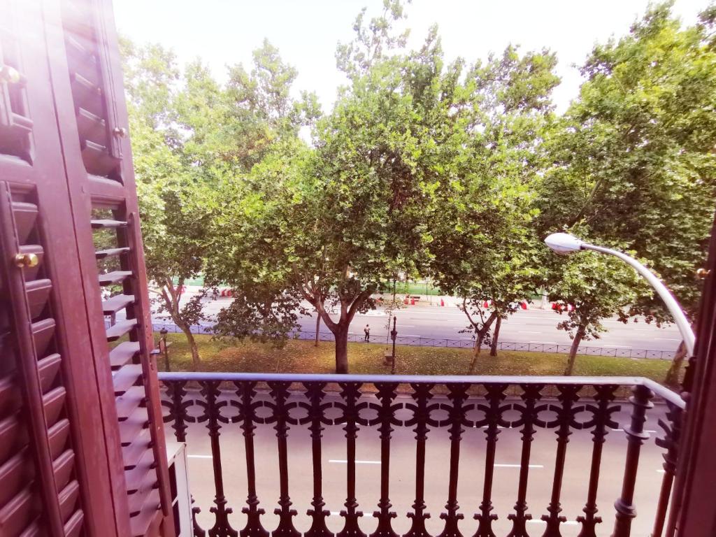 a view from a porch with a fence and trees at Casa de Huespedes La Asturiana in Madrid