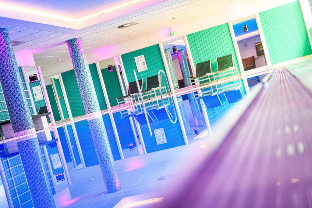 a hospital hallway with blue and green walls and columns at Holiday Inn Lübeck, an IHG Hotel in Lübeck