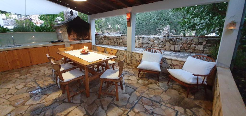 a patio with a table and chairs and a fireplace at Apartman Šego in Vela Luka