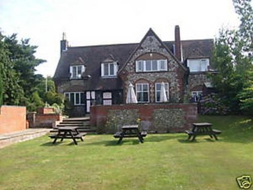 uma casa com mesas de piquenique em frente em The William IV em Norwich