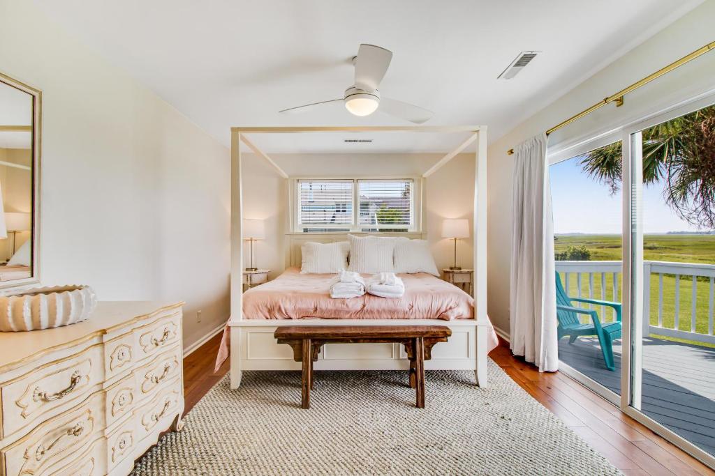 a bedroom with a bed and a large window at Belle Mare in Folly Beach